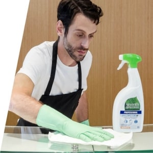 Man cleaning glass surface with Seventh Generation Professional Man cleaning glass surface with Seventh Generation Professional