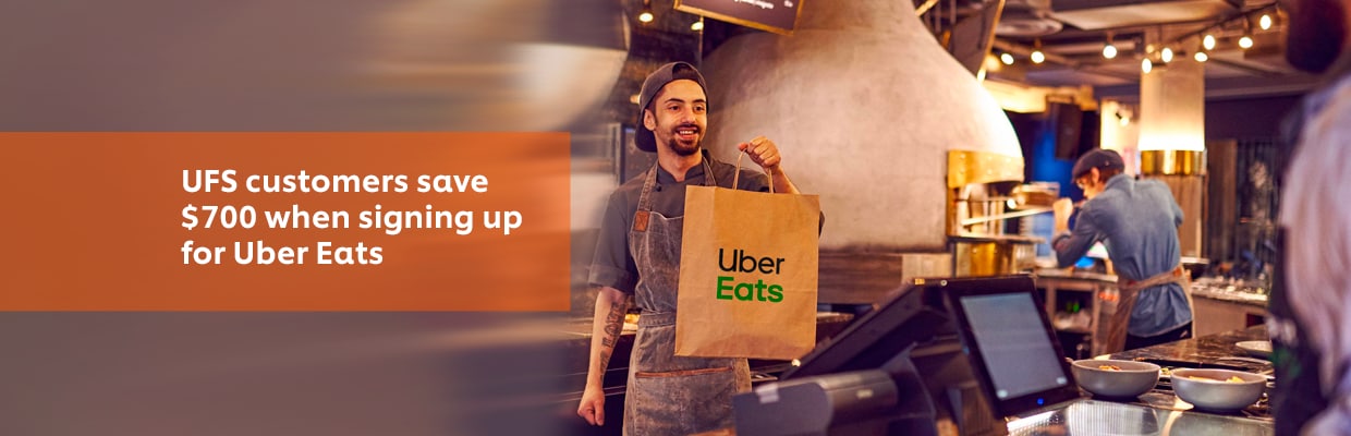 Restaurant employee holding an Uber Eats Food Delivery Bag Restaurant employee holding an Uber Eats Food Delivery Bag